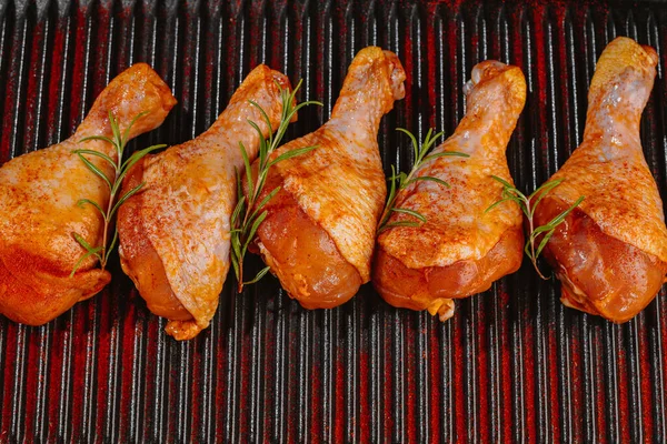 Marinated chicken dramstick on a griddle pan. Top view.Convenience food,pree cooked.Raw chicken for grilling with spices for cooking.