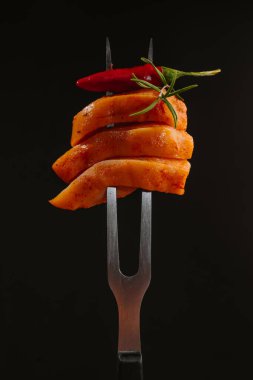 Çiğ tavuk eti. Siyah arkaplanda çatalla ince dilimlenmiş tavuk filetosu. Diyet yemek. Düşük kalorili.