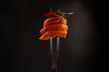 Çiğ tavuk eti. Siyah arkaplanda çatalla ince dilimlenmiş tavuk filetosu. Diyet yemek. Düşük kalorili.