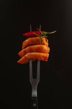 Çiğ tavuk eti. Siyah arkaplanda çatalla ince dilimlenmiş tavuk filetosu. Diyet yemek. Düşük kalorili.