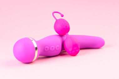 Collection of different types pink and violet of sex toys on pink background.Sex toys.Double vaginal balls and dildo vibrator and anal plug.