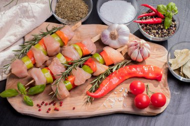 Taze tavuk kebabı. Siyah tabakta çiğ tavuk şişi. Baharatlar ve ahşap arka planda yeşil biberiye. Çiğ tavuk. .
