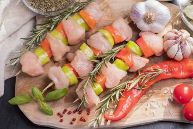 Taze tavuk kebabı. Siyah tabakta çiğ tavuk şişi. Baharatlar ve ahşap arka planda yeşil biberiye. Çiğ tavuk. .