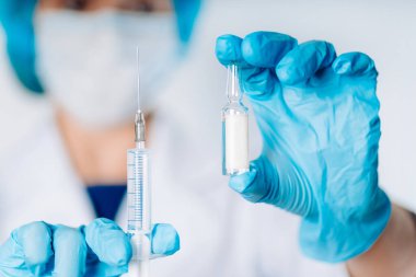 Şırınga ve ampul, şişe, elinde tıbbi enjeksiyon, avuç içinde ya da parmaklarında. Doktor elinde aşı olan bir ampulü elinde tutuyor. Nüfusun aşılanması. Aşı önerilir. Hastanede sağlık hizmeti.