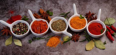 Kaşık üzerinde çeşitli baharatlar ve defne yaprakları..