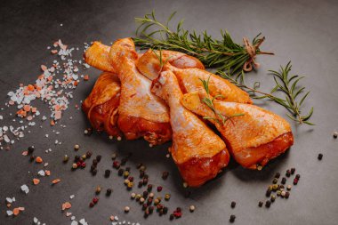 Çiğ salamura edilmiş tavuk budu baharat serpiştirilmiş, acı biber parçaları, körfez yaprakları pişmeye hazır, yukarıdan manzaralı. Baharatlı kırmızı salamura edilmiş tavuk salamura edilmiş tavuk. Çiğ terbiye edilmiş tavuk eti. Çiğ but..