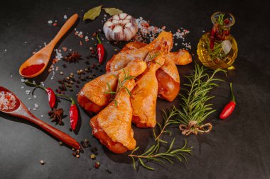 Çiğ salamura edilmiş tavuk budu baharat serpiştirilmiş, acı biber parçaları, körfez yaprakları pişmeye hazır, yukarıdan manzaralı. Baharatlı kırmızı salamura edilmiş tavuk salamura edilmiş tavuk. Çiğ terbiye edilmiş tavuk eti. Çiğ but..