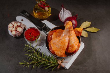 Çiğ salamura edilmiş tavuk budu baharat serpiştirilmiş, acı biber parçaları, körfez yaprakları pişmeye hazır, yukarıdan manzaralı. Baharatlı kırmızı salamura edilmiş tavuk salamura edilmiş tavuk. Çiğ terbiye edilmiş tavuk eti. Çiğ but..