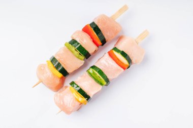 İki tane tavuk kebabı ve sebzeli beyaz tabak. Perakende için tavuk kebabı.