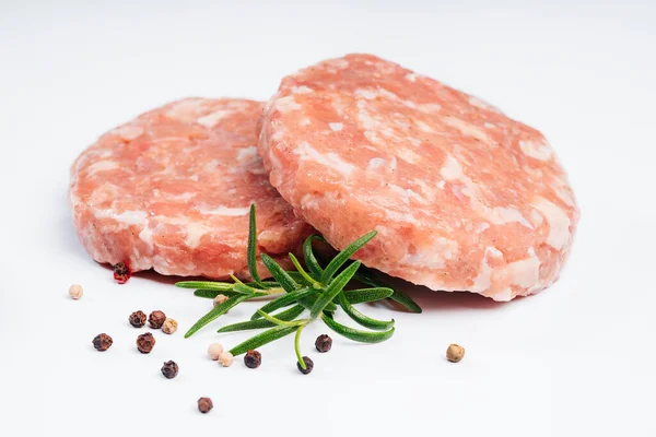 Biberiye dalı ve baharatlarla beyaz tabakta çiğ tavuk burger. Anında et. Izgara hamburger, çiğ hamburger, beyaz arka planda köfte. Evde fast food, hazır yemek..