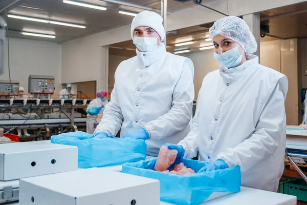 Yiyecek ürünleri konveyördeki plastik ambalajda tavuk eti. Et üretimi için ambalaj ve kesim hattı. Et işleme tesisi. Et paketleme ve kesme ile üretim hattı..