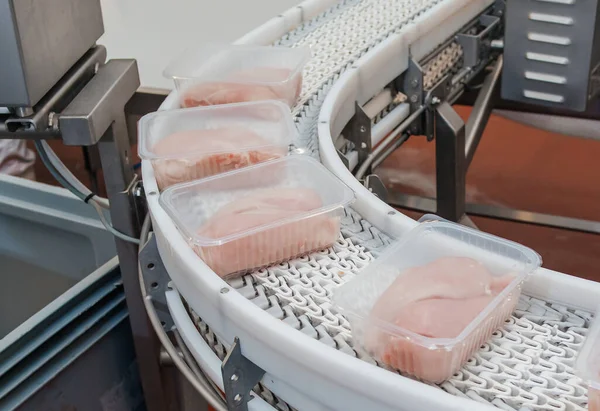 Paketleme ve et kesme ile üretim hattı. Yiyecek ürünleri konveyörde plastik ambalajda tavuk eti. Et ürünleri üretimi için fabrika..