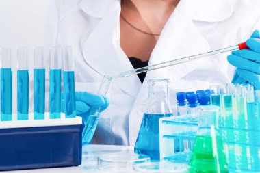 Yeni aşıların geliştirilmesi. Laboratuvar arka planında laboratuvar camları ve test tüpleri bulunan bilim adamlarının elleri, laboratuvar araştırma ve geliştirme kavramları. Laboratuvar ekipmanları. Coronavirus pandemic stop. Tıp konsepti