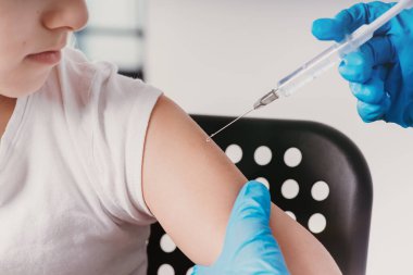 Doktor elinde şırınga ile aşı yapıyor. Aşı yapıyor. Nüfusun aşısı. Aşı önerilmektedir. Grip gribi aşısı klinik deney konsepti, korona virüsü tedavisi, yakın plan .