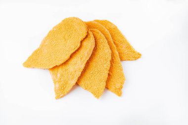 Beyaz arka planda dilimlenmiş beş dilim kızarmış tavuk şnitzel fileto. Çiğ tavuk filetosu serpiştirildi..