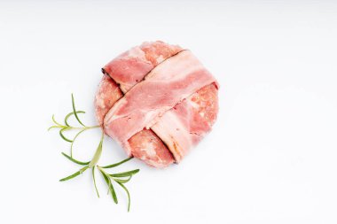 Beyaz tabakta domuz pastırmalı hamburger ve biberiye dalı. Çiğ tavuk burger..