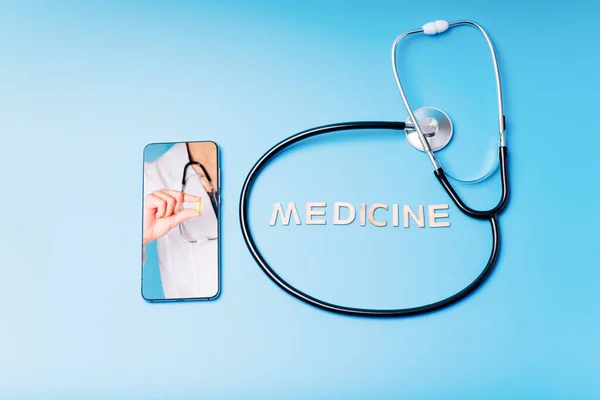 Female doctor chatting online with patients.Copy space. Stethoscope on a blue background with place for text, online doctor. Calling a doctor by phone.Health concept. The doctor can examine the patient via video call.