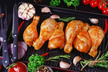 Ogranik yemek ve sağlıklı beslenme kavramı. Tavuk budu pişirme. Biberiye ve biberiyeli salamurada çiğ tavuk bacağı..