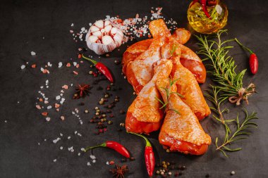 Ogranik yemek ve sağlıklı beslenme kavramı. Tavuk budu pişirme. Biberiye ve biberiyeli salamurada çiğ tavuk bacağı..