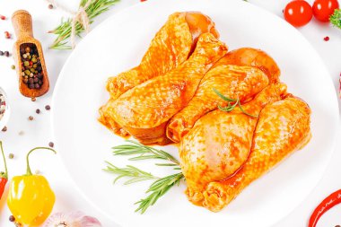 Ogranik yemek ve sağlıklı beslenme kavramı. Tavuk budu pişirme. Biberiye ve biberiyeli salamurada çiğ tavuk bacağı..