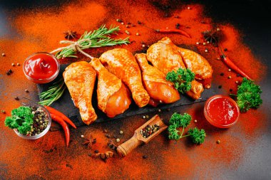 Baharatlı çiğ tavuk budu ve siyah arka planda yeşil biberiye. Uygun yemek, hazır tavuk budu. Taze tavuk budu..