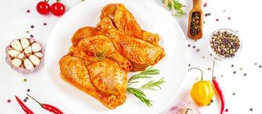 Baner. Tavuk budu pişiriyorum. Arka planda biberiyeli salamurada çiğ tavuk budu. Soslu tavuk kanadı..