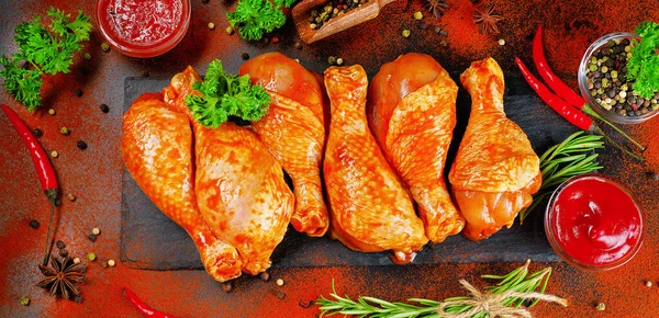 Siyah arka planda siyah bir yemek tahtasında taze biberiye yapraklarıyla marine edilmiş ızgara tavuk dolması. Yarı bitmiş ürün, marine edilmiş ürün, yemek pişirme. Baharatlı et pankartı..