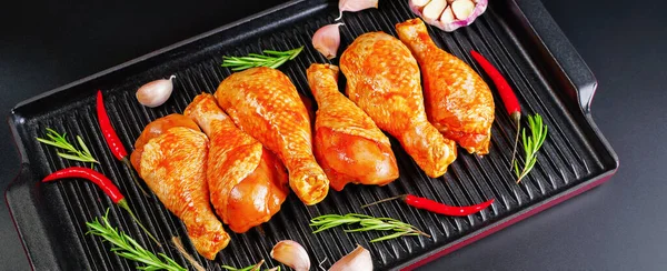 Convenience food, precooked.Background for a banner of meat with spices.Raw Marinated chicken meat leg swith spices for cooking for BBQ dark background. Top view.