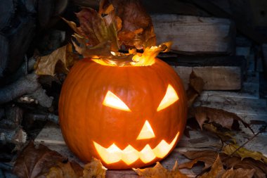 Korkunç cadılar bayramı dekoratif aydınlatılmış balkabağı yüzü Ekim 'de karanlık bir ahırda