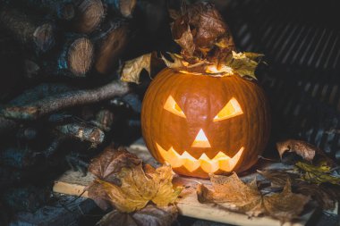 Korkunç cadılar bayramı dekoratif aydınlatılmış balkabağı yüzü Ekim 'de karanlık bir ahırda