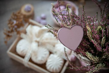 Aziz Sevgililer Günü için ahşap kalp, zephyr, krema, çiçekler ve ahşap dekorla yemek tasarımı.