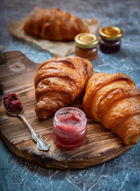 Antika ahşap tahtanın üzerinde taze kruvasan ve meyve reçeli taşralı stili.