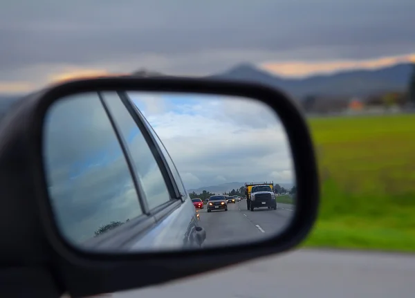 Vista de estrada no espelho lateral em um carro — Fotografia de Stock