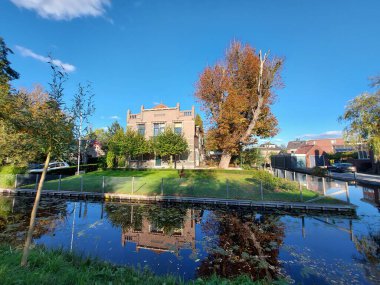 Gouda şehrinde sudaki ağaçların yansıması. Sonbaharda renkli yapraklarla.