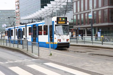 Hollanda 'nın Zuidas bölgesinde Amsterdam sokaklarında beyaz ve mavi tramvay