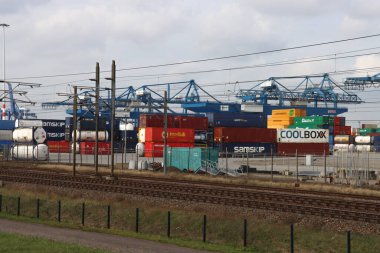 Hollanda 'da Rotterdam limanında deniz konteynırları depolanmış tren ve turnalar.