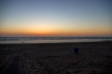 Güneş, Hollanda 'daki renkli gökyüzü ile Katwijk plajında denize batar.