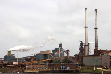 Hollanda 'nın IJmuiden kentindeki Tata çelik fabrikasının bacalarından buhar çıkıyor.