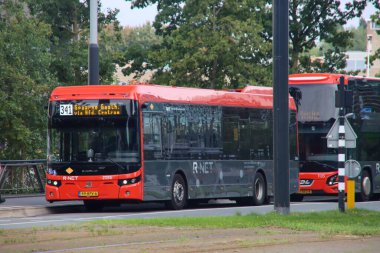 R-NET kırmızı ve siyah otobüsler Amsterdam Zuid 'de bağlantı tarafından çalıştırılıyor.