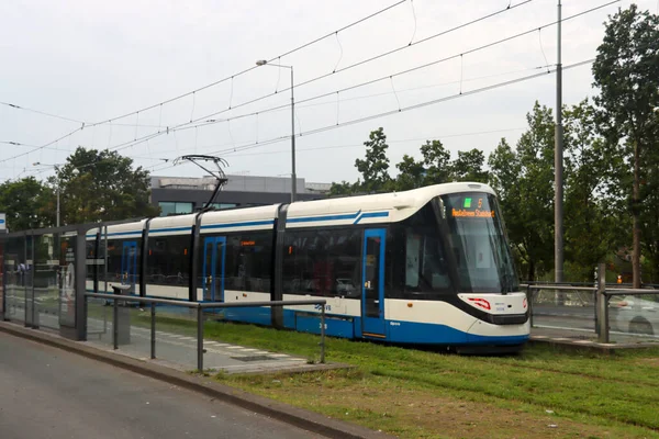 アムステルダム ジッド駅でGvbが5号線で運行している青と白のUrbos 100 Caf路面電車 — ストック写真