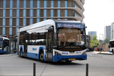 Amsterdam, Hollanda - 11 Ağustos 2025 - Amsterdam 'ın mavi ve beyaz şehir otobüsleri Amstel istasyonunda yerel hizmet için. 