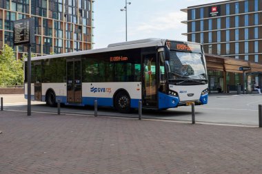 Amsterdam, Hollanda - 11 Ağustos 2025 - Amsterdam 'ın mavi ve beyaz şehir otobüsleri Amstel istasyonunda yerel hizmet için. 