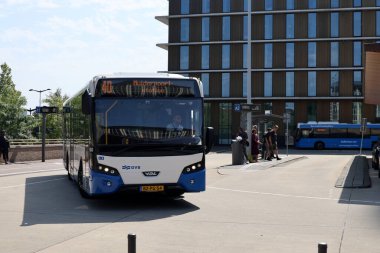 Amsterdam, Hollanda - 11 Ağustos 2025 - Amsterdam 'ın mavi ve beyaz şehir otobüsleri Amstel istasyonunda yerel hizmet için. 