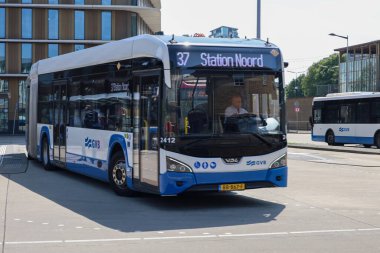 Amsterdam, Hollanda - 11 Ağustos 2025 - Amsterdam 'ın mavi ve beyaz şehir otobüsleri Amstel istasyonunda yerel hizmet için. 