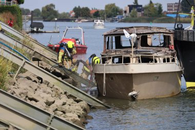 İtfaiye Hollandsche IJssel 'deki bir yatta tamamen yangınla meşgul. Çelik duvarı geçmek için kobra kesici kullanıyorlar.