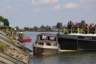 İtfaiye Hollandsche IJssel 'deki bir yatta tamamen yangınla meşgul. Çelik duvarı geçmek için kobra kesici kullanıyorlar.