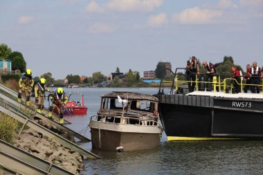 İtfaiye Hollandsche IJssel 'deki bir yatta tamamen yangınla meşgul. Çelik duvarı geçmek için kobra kesici kullanıyorlar.