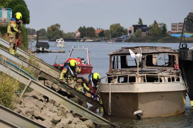 İtfaiye Hollandsche IJssel 'deki bir yatta tamamen yangınla meşgul. Çelik duvarı geçmek için kobra kesici kullanıyorlar.