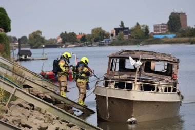 İtfaiye Hollandsche IJssel 'deki bir yatta tamamen yangınla meşgul. Çelik duvarı geçmek için kobra kesici kullanıyorlar.