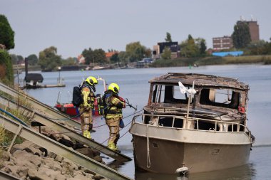 İtfaiye Hollandsche IJssel 'deki bir yatta tamamen yangınla meşgul. Çelik duvarı geçmek için kobra kesici kullanıyorlar.